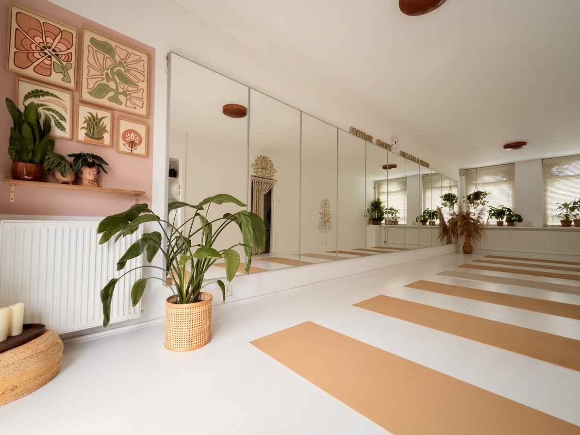 De lichte yogastudio van Karina met yogamatten, planten en een spiegelwand